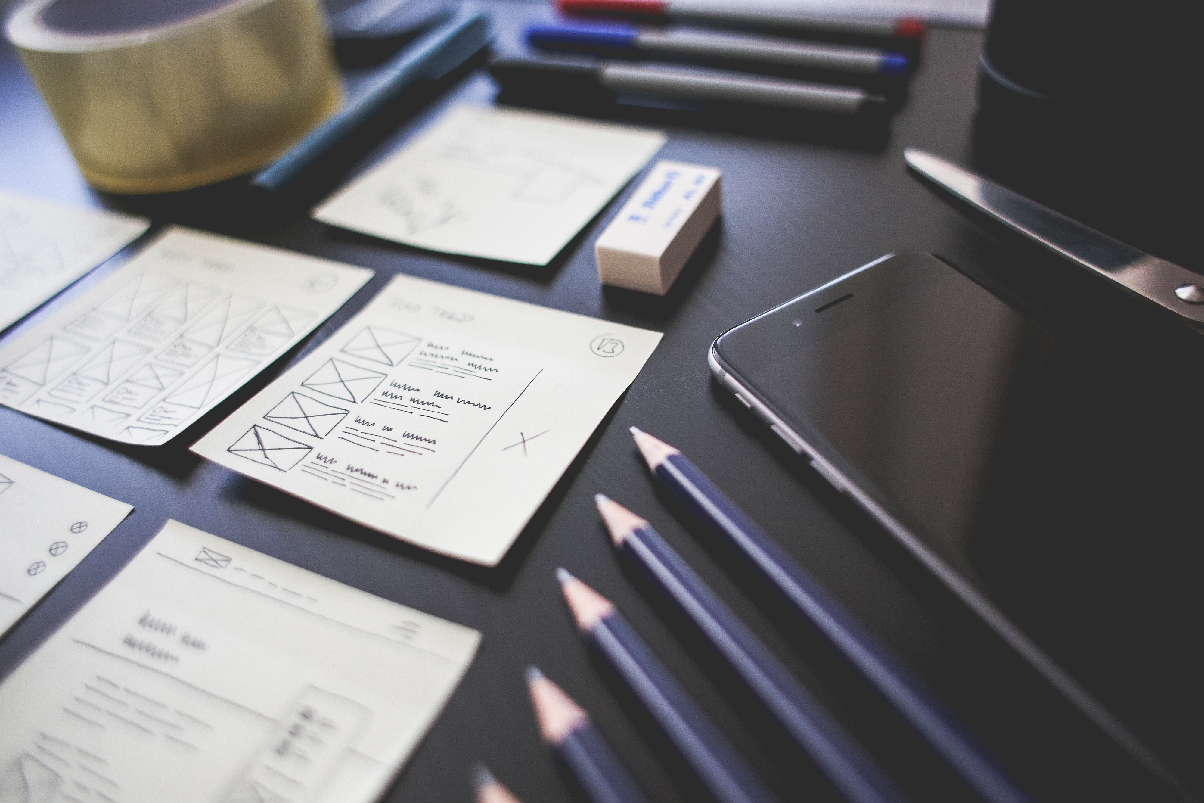 Pencils and website wireframes on a desk.
