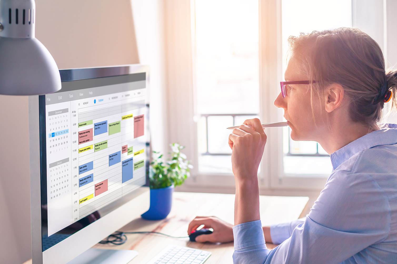 Woman using crowded calendar on computer
